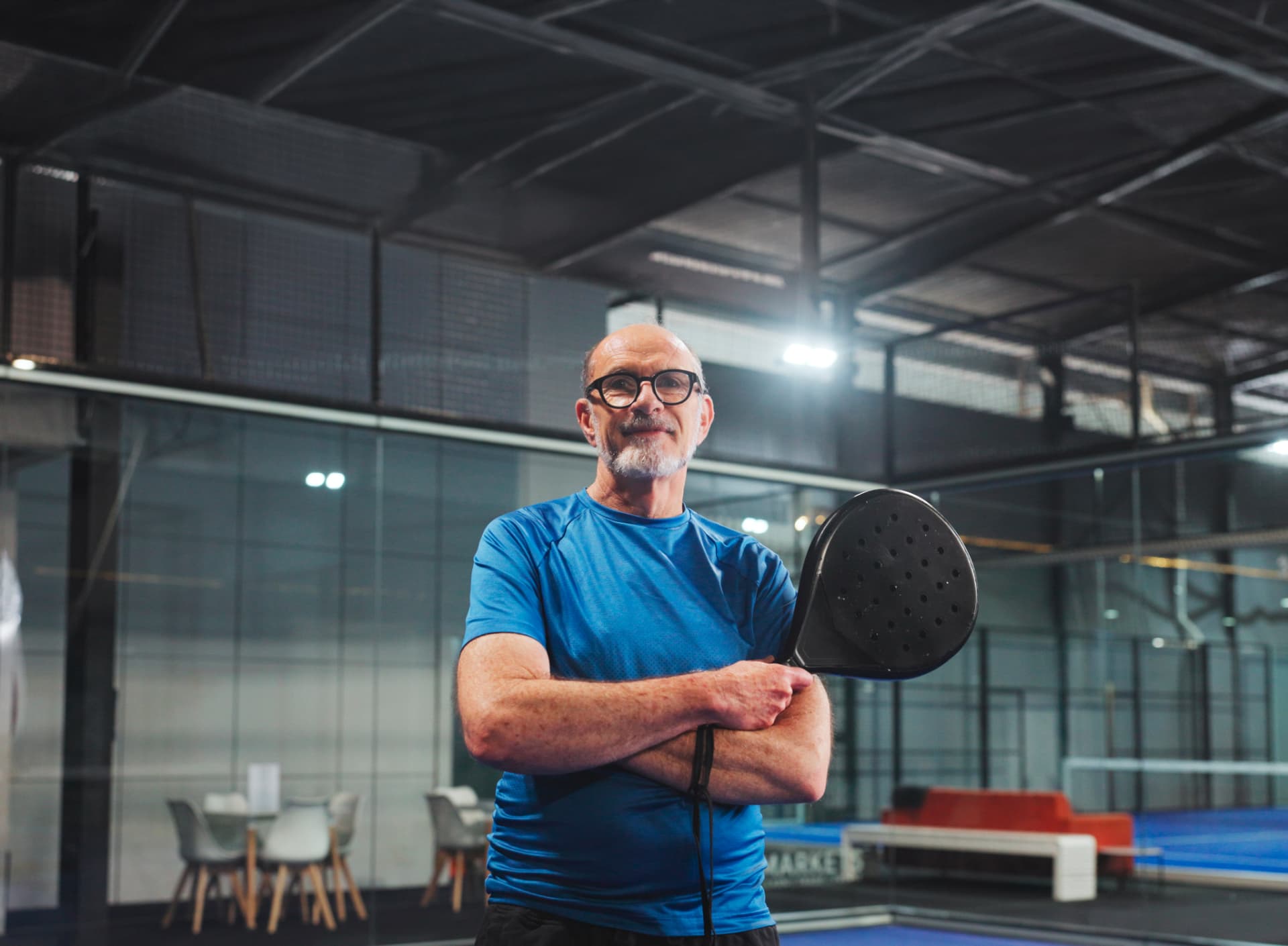 Joueur senior sur une piste de padel indoor