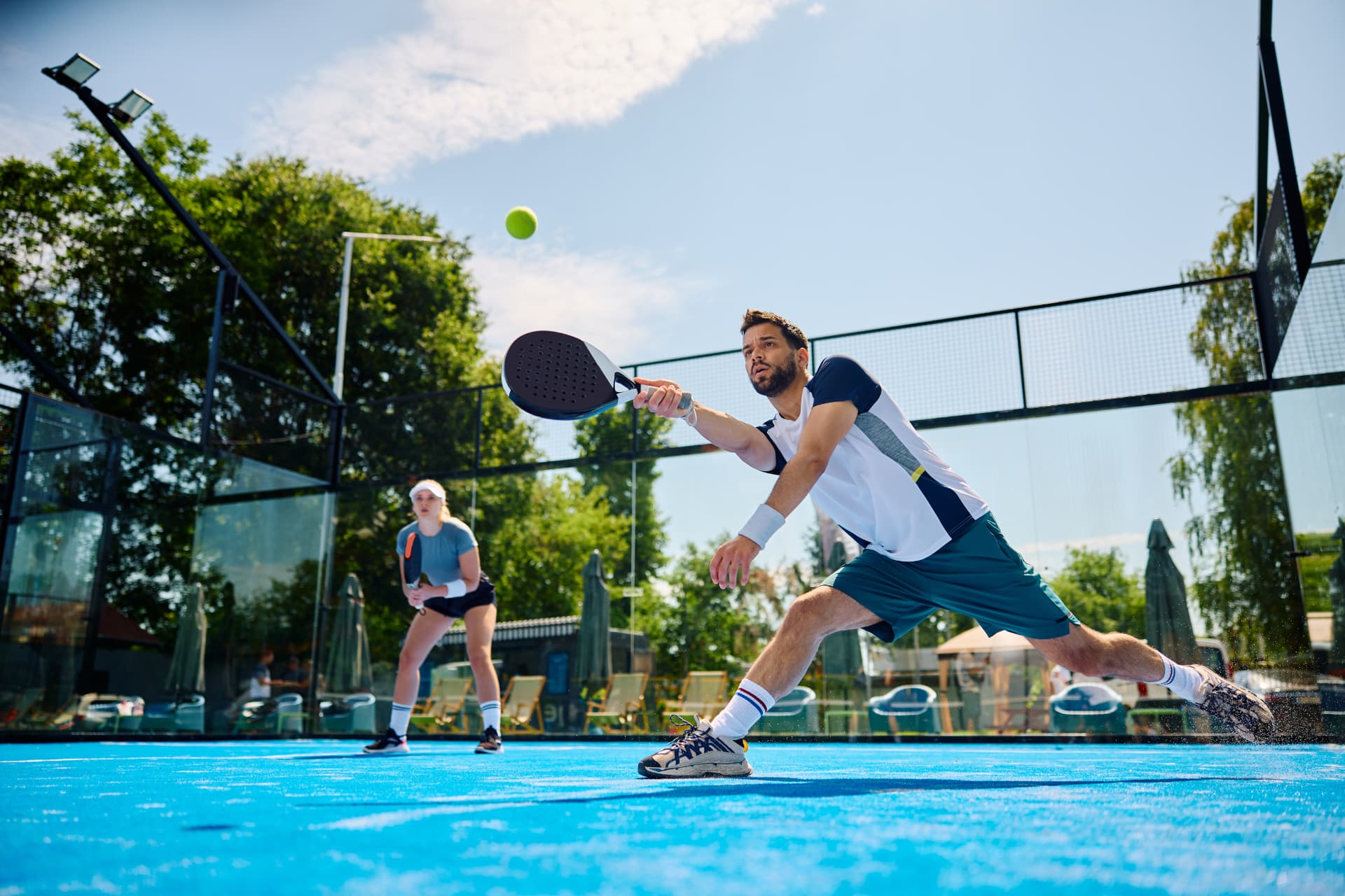 Joueur de padel frappant la balle lors d'un tournoi amical